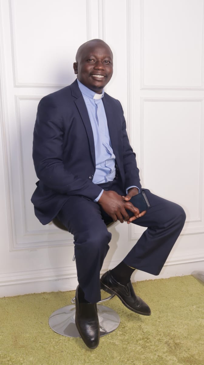 Portrait Pastor Navy Suit Seated Pose Smiling